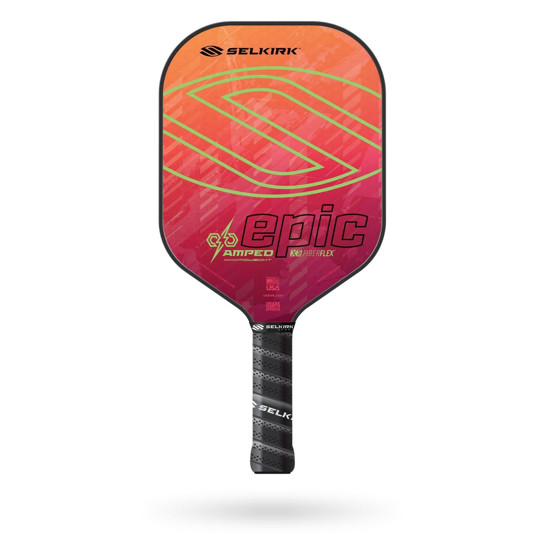 The Selkirk Amped Epic Pickleball Paddle boasts a vibrant orange to pink gradient design with a sleek black edge guard. This high-performance paddle features the Selkirk logo, "epic AMPED" branding, and comes with a Limited Lifetime Warranty.