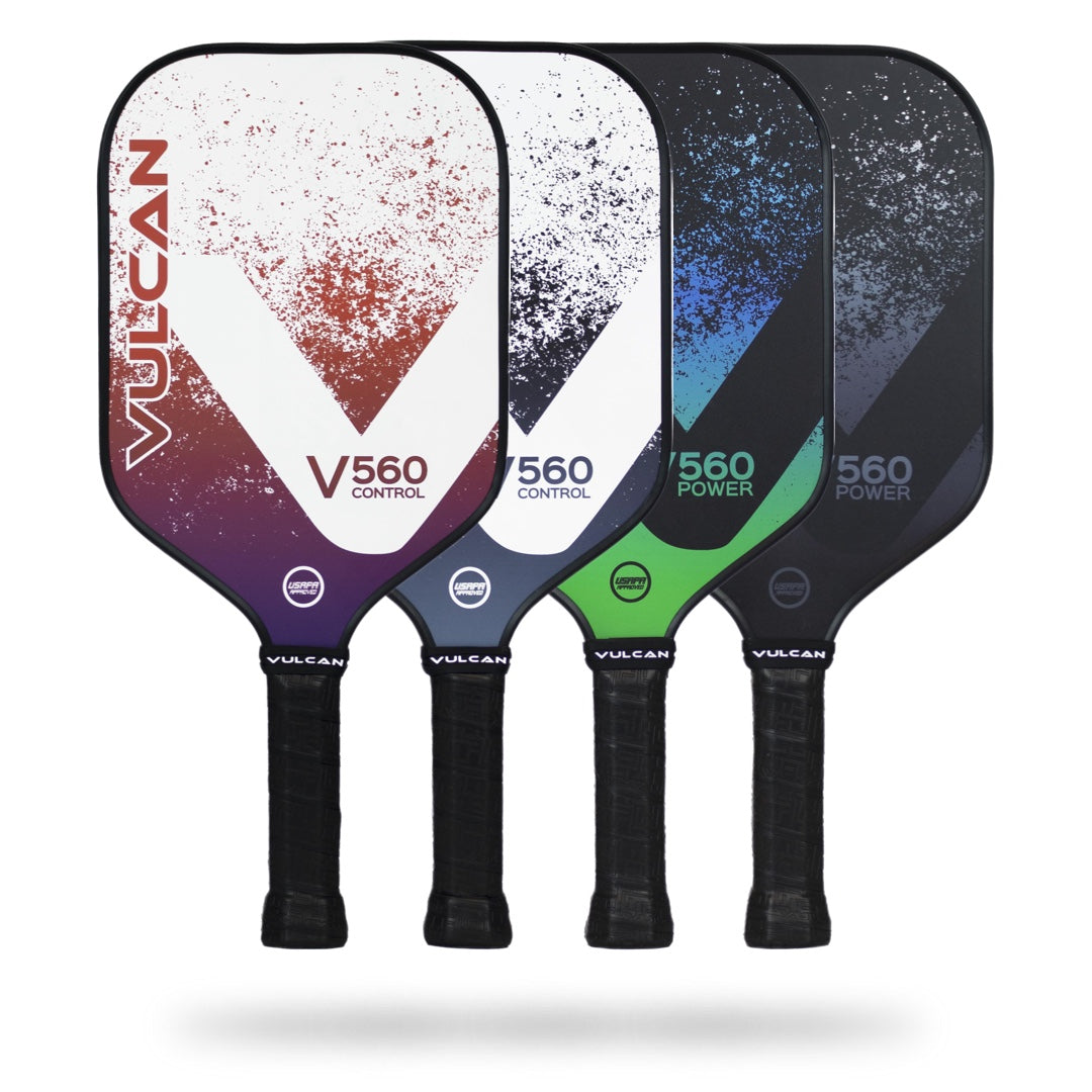 Four Vulcan V560 Pickleball Paddles are displayed upright, lined up side by side. The paddles have different color schemes and are labeled Vulcan V560 Control or 560 for variations in power and precision, ideal for all-court players seeking versatility with a durable polypropylene core.