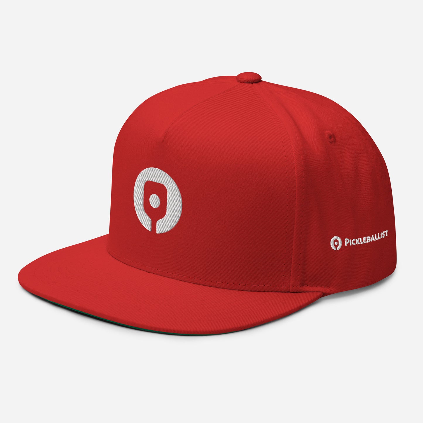 The Pickleballist Signature Logo Flat Brim Pickleball Hat by Pickleballist is a red snapback with a high-profile fit, featuring a white circular logo on the front and the word "PICKLEBALLIST" in white letters on the side.