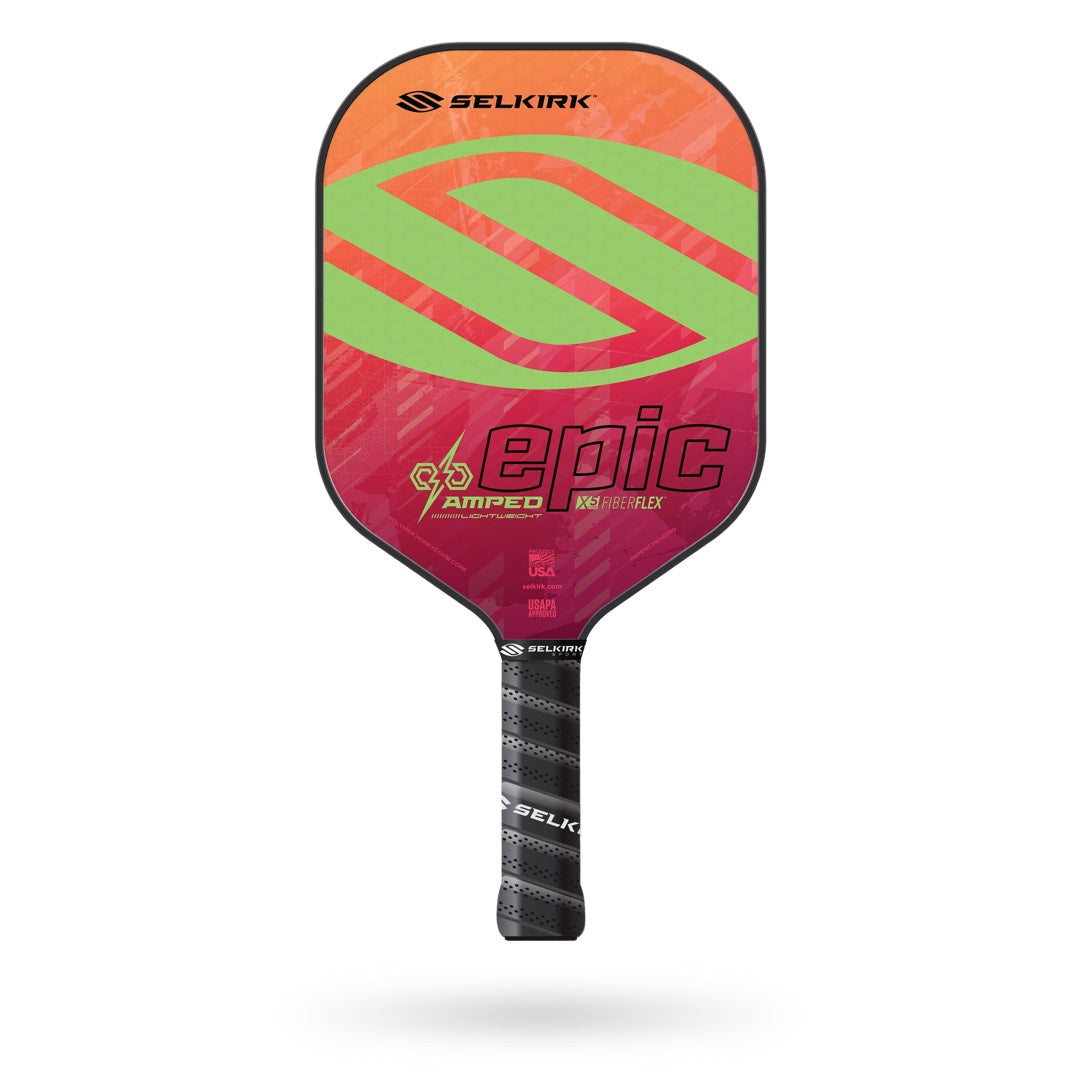 A Selkirk Amped Epic Pickleball Paddle features a red, pink, and green design with a black grip. This high-performance paddle comes with a Limited Lifetime Warranty.