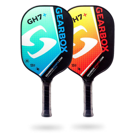 Two Gearbox GH7+ Pickleball Paddles with black handles are shown. One paddle is turquoise with white and black details, the other is red and yellow with white and black details. Both paddles feature superior construction for enhanced gameplay.