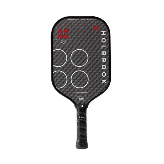 The Holbrook Arma X Metallic 14mm pickleball paddle features a textured black surface, four white circles, and "ARMA" and "HOLBROOK" branding. It includes a Dual-Density™ Core for enhanced performance.