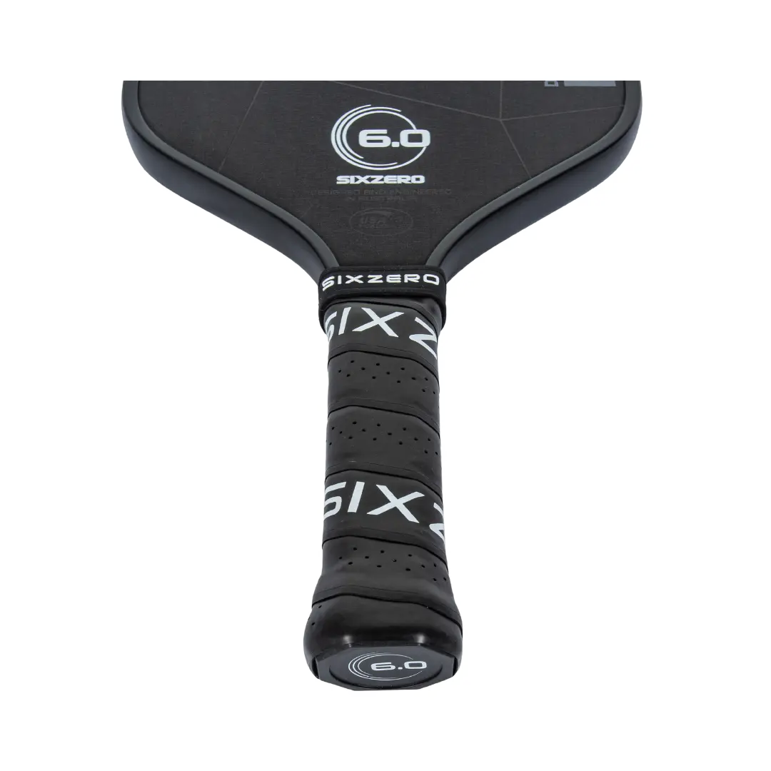 Close-up of a black Six Zero Double Black Diamond Control (14mm) Pickleball Paddle handle wrapped in black grip tape with "SIXZERO" and "6.0" logos visible.