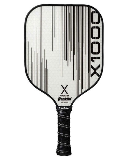 A white Franklin X-1000 Pickleball Paddle with black vertical lines and "X-1000" printed on its surface. The paddle has a black grip, features the Franklin brand logo, and boasts a durable polypropylene core.