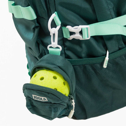 A yellow perforated pickleball sits in a small green JOOLA pouch, which is attached to the dark green JOOLA Utility Backpack.