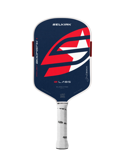 The Selkirk LABS Project Boomstik Elongated 16mm Pickleball Paddle with Infinigrit features a dark blue face, red and white graphic design, and a white grip—ideal for advanced spin. Displayed on a plain white background.