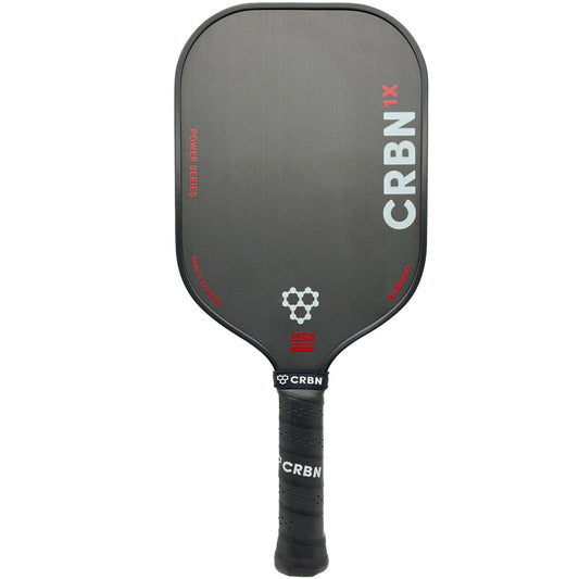 A gray Pickleballist CRBN 1X Power Series - 14mm Elongated pickleball paddle with a textured surface featuring the brand logo and red accents, marked as made in the USA.