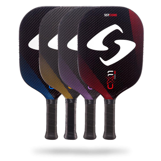 Four colorful Gearbox CX11 Quad Pickleball Paddles with black handles are displayed in a row, each paddle showcasing a different accent color: blue, yellow, purple, and red. Designed with the advanced SST ribbed core and CX11 Quad Control technology, these paddles offer a larger sweet spot for improved precision.