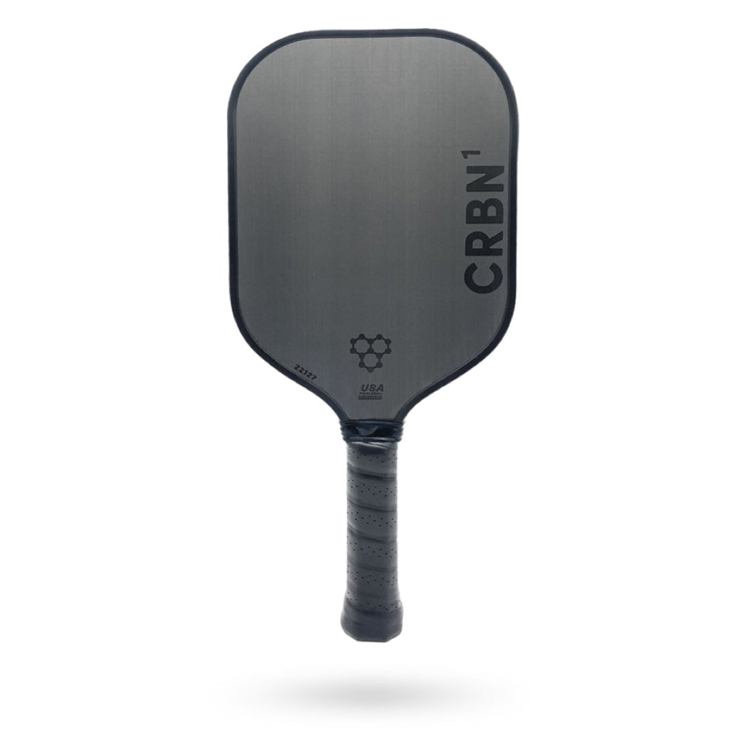 A gray carbon fiber CRBN 1 - 16mm Pickleball paddle isolated on a white background, labeled "crbn" with a grip wrapped in black material.