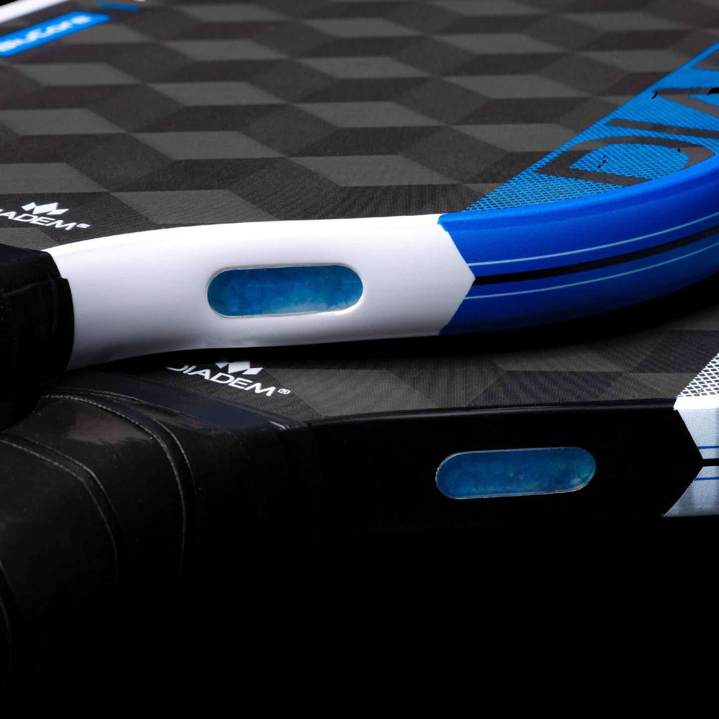 Diadem Edge BluCore Pro 16mm Pickleball Paddle by Diadem: Close-up highlights its textured surface, blue and white details, and transparent window-like features on the frame.