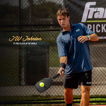 A man in a blue shirt and black shorts is playing pickleball on an outdoor court, holding a Franklin Sweet Spot Training Pickleball Paddle made from T700 carbon fiber. He is about to hit the ball. The text reads "JW Johnson, #1 pro player in the world.