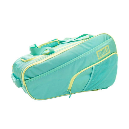 The Pickleballist 2026 Tour Elite Pro Pickleball Bag in turquoise and yellow features a front zip pocket, mesh side pocket, and top handles—ideal for tournament players, displayed against a white backdrop.