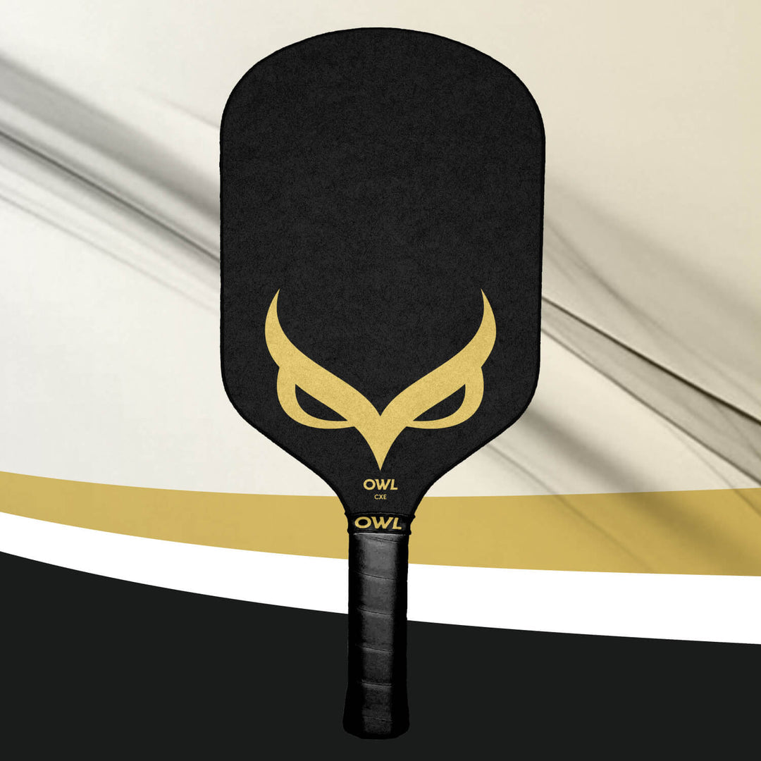 The OWL CXE - Drew Brees Limited Edition Quiet Pickleball Paddle by OWL features a gold owl face and "OWL" logo, crafted with Propylux Acoustene composite, in bold white, gold, and black—ideal for collectors and serious players.