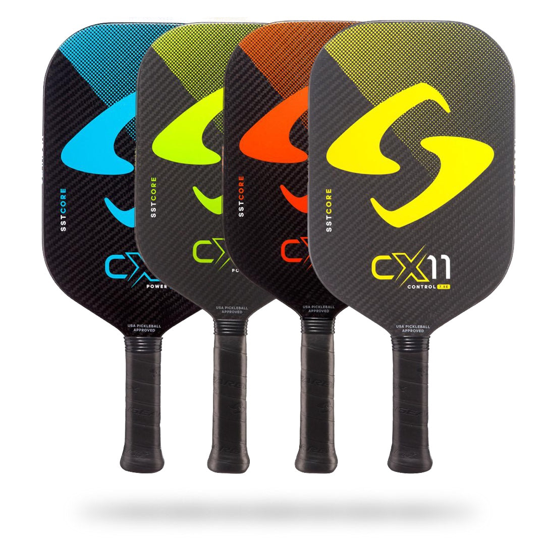 Four Gearbox CX11 Elongated Pickleball Paddles in a row, each featuring a vibrant color (blue, green, red, yellow) and a large "s" logo on the paddle face by Pickleballist.