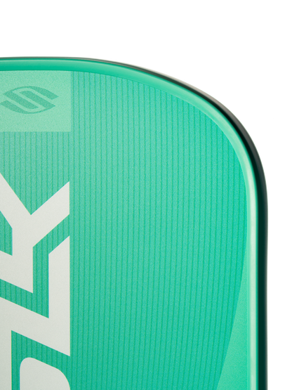 Close-up of the top section of a Selkirk SLK Valkyrie Widebody 16mm Pickleball Paddle, featuring green and teal color, a logo, and bold partial white lettering on its surface.