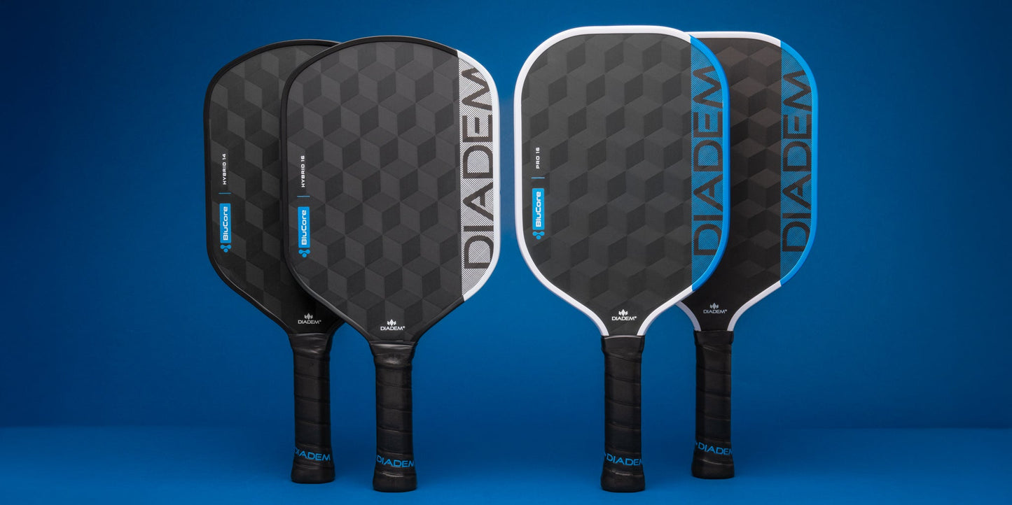 Four Diadem Edge BluCore Pro 16mm Pickleball Paddles with black and blue geometric designs stand upright against a blue background, highlighting the sleek style of these paddles from Diadem.