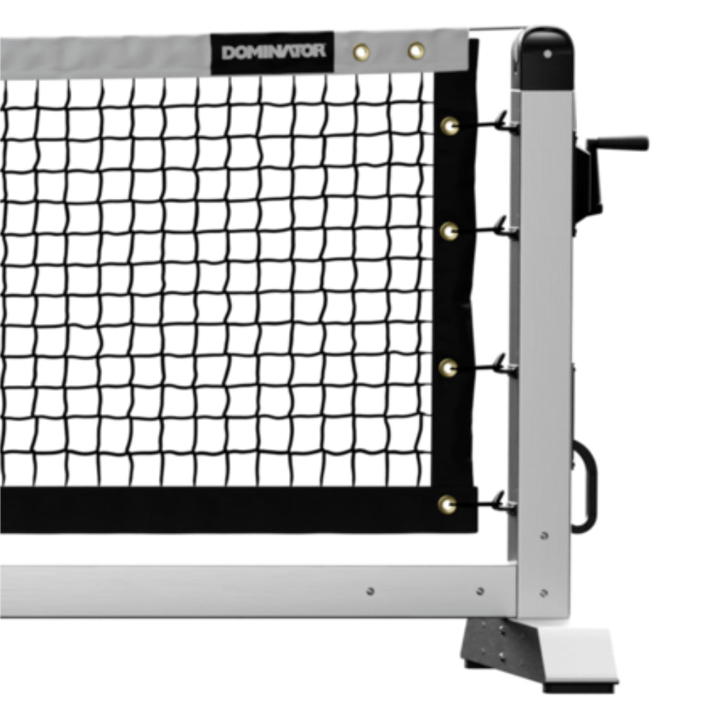 Close-up of a pickleball net attached to a sturdy metal post. The Dominator Pro Max Portable Pickleball Net features a tension adjustment mechanism and "Dominator" branding on the top band.