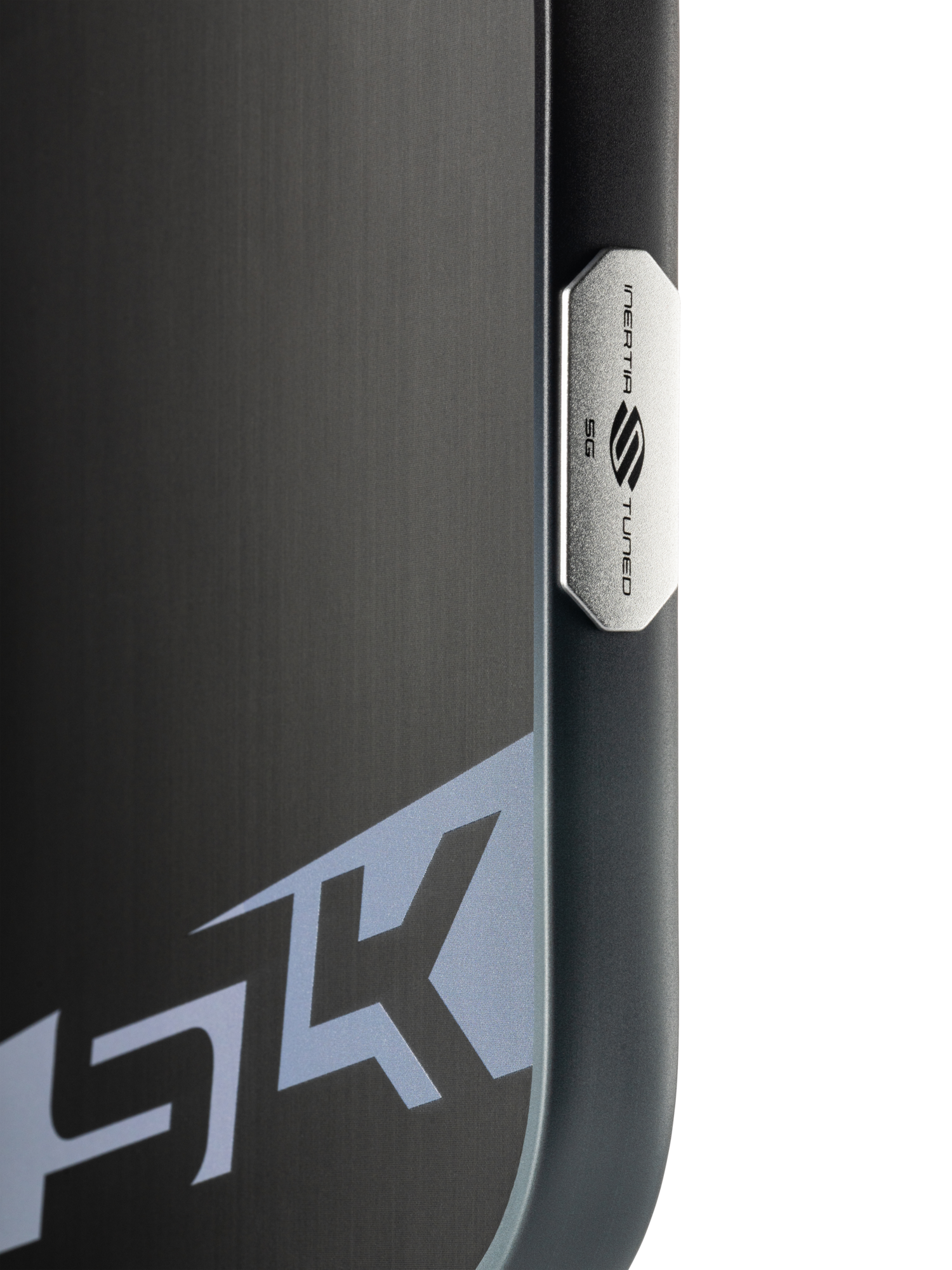 Close-up of a black device with a brushed metal finish, featuring the "SK" logo and a metallic badge labeled "NEBULA TURBO SG5," evoking the precision of the Selkirk SLK Dauntless Elongated 16mm Pickleball Paddle.