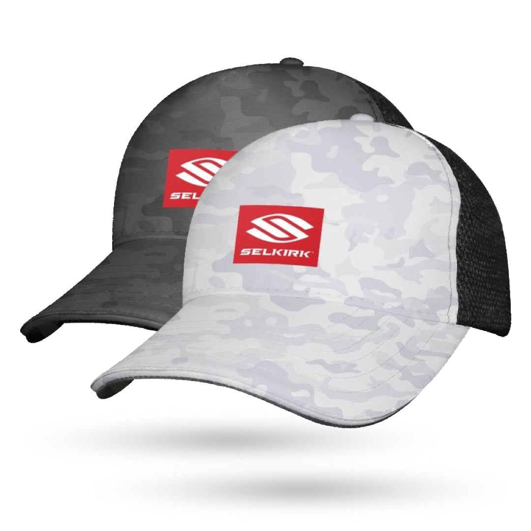 Two camouflage baseball caps with black mesh sides, featuring a red square logo with "Selkirk" text and emblem. One cap is dark gray, and the other is light gray. These Selkirk Red Label Camo Sport Trucker Pickleball Hats from Selkirk are designed with Stretch-Wik for maximum comfort and breathability.