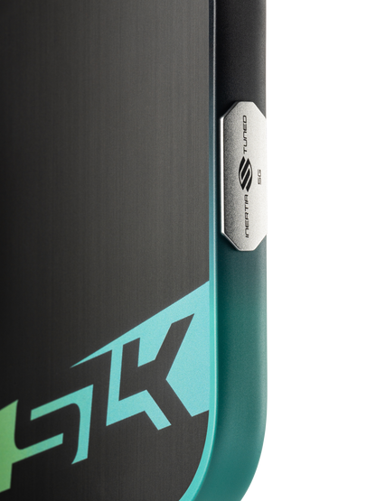 Close-up of the Selkirk SLK Dauntless Widebody 16mm Pickleball Paddle shows a metallic button labeled "Snapdragon Sound" and a partial "5K" graphic on its teal and black surface.